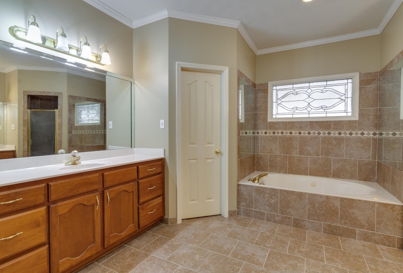 Full bath with crown molding, vanity, and light tile patterned floors