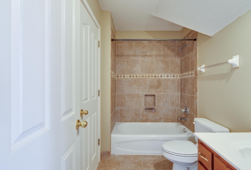 Full bathroom with shower / bath combination, vanity, light tile patterned flooring, and a textured ceiling