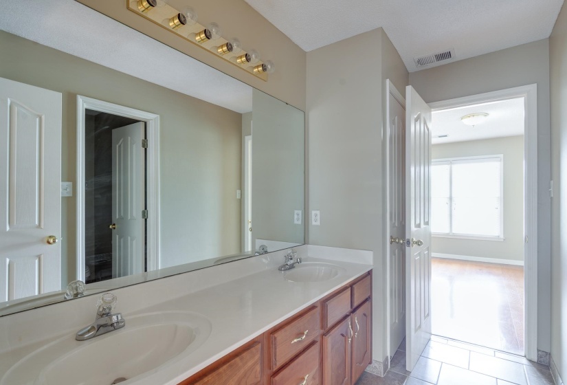 Full bath featuring double vanity and light tile patterned flooring