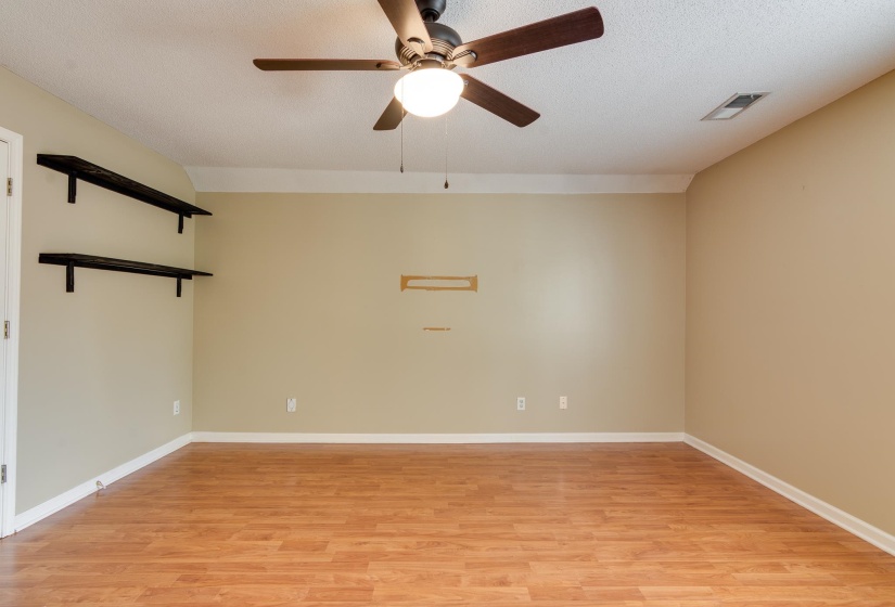 Unfurnished room featuring light wood-type flooring, ceiling fan, and a textured ceiling