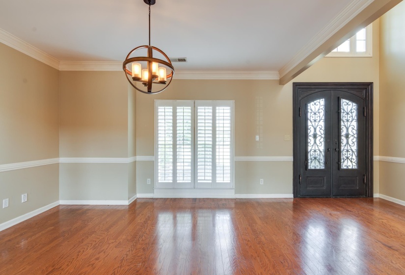 Foyer entrance featuring crown molding, wood finished floors, a chandelier, and french doors