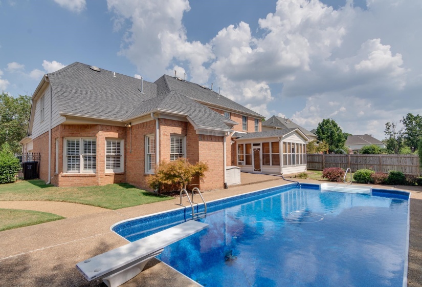 View of pool with a sunroom, a diving board, and a patio area