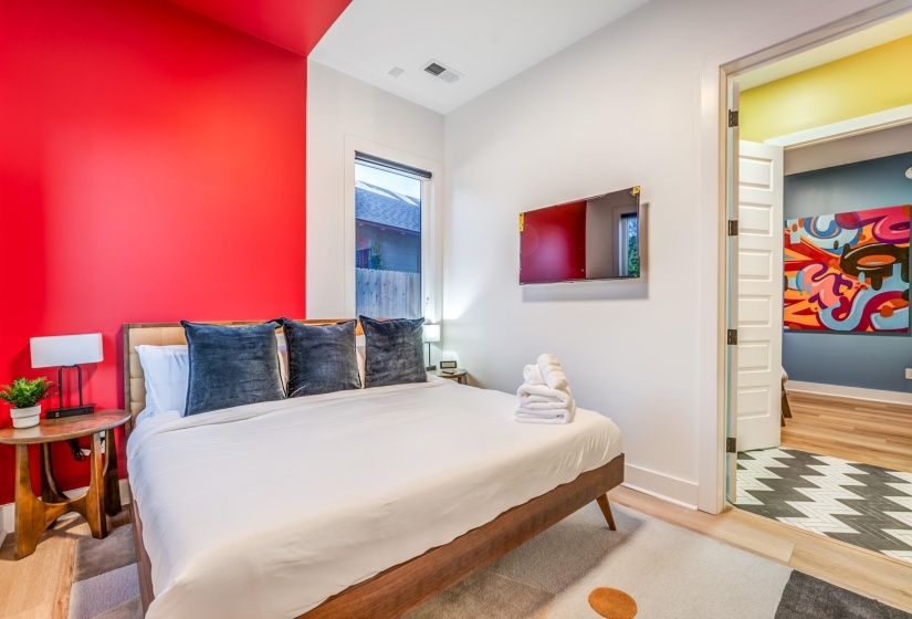 Bedroom with baseboards, wood finished floors, and visible vents
