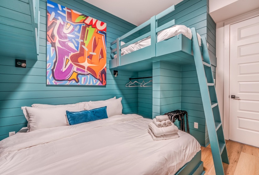 Bedroom with wood finished floors and wood walls