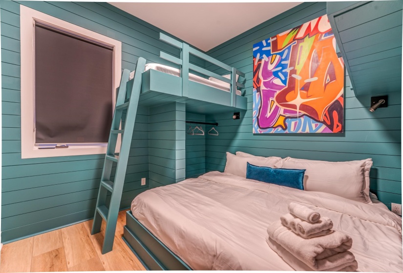 Bedroom featuring wood finished floors and wood walls