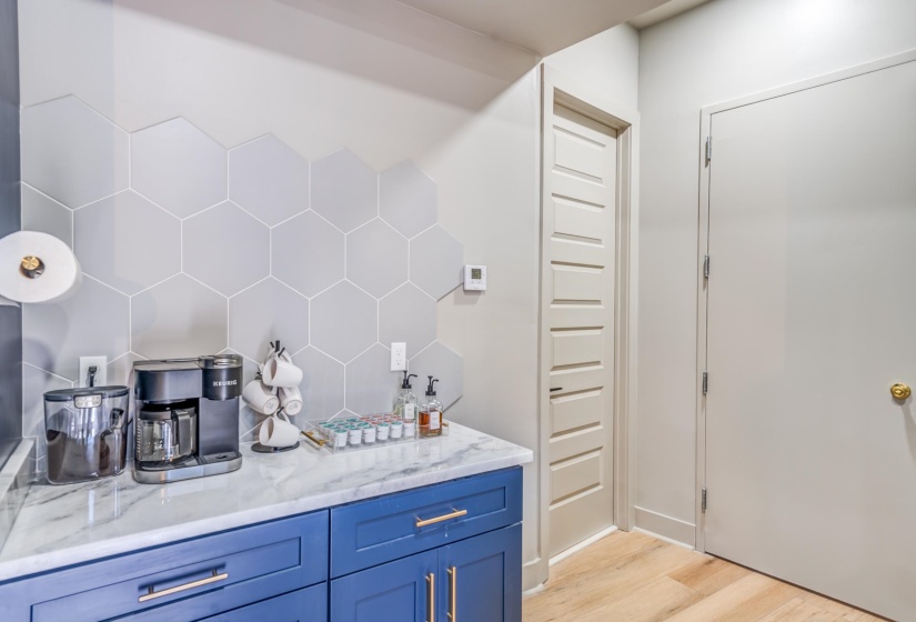 Bar featuring decorative backsplash and light wood-style floors