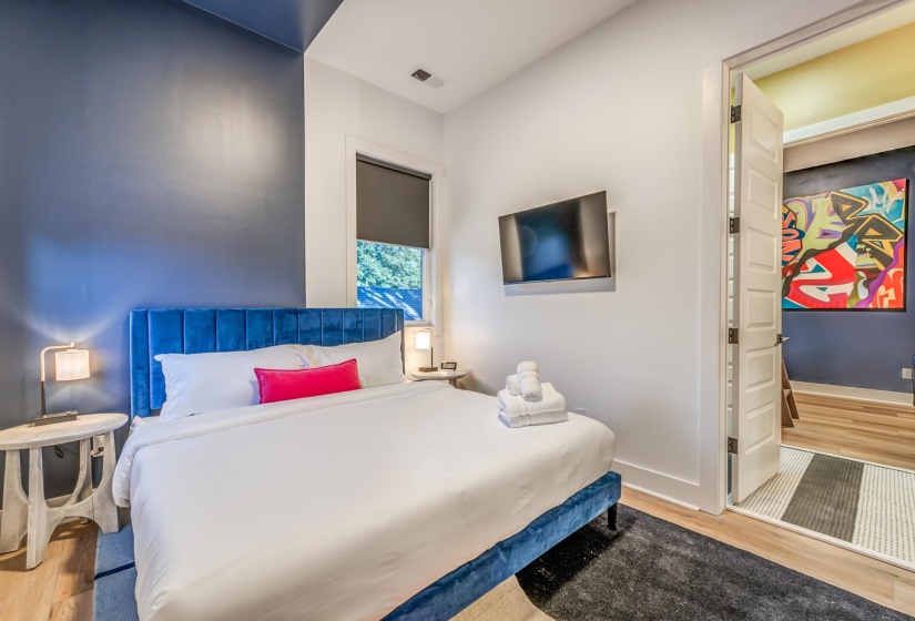Bedroom with wood finished floors, visible vents, and baseboards