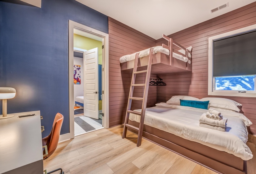 Bedroom featuring wood finished floors, visible vents, wood walls, and baseboards
