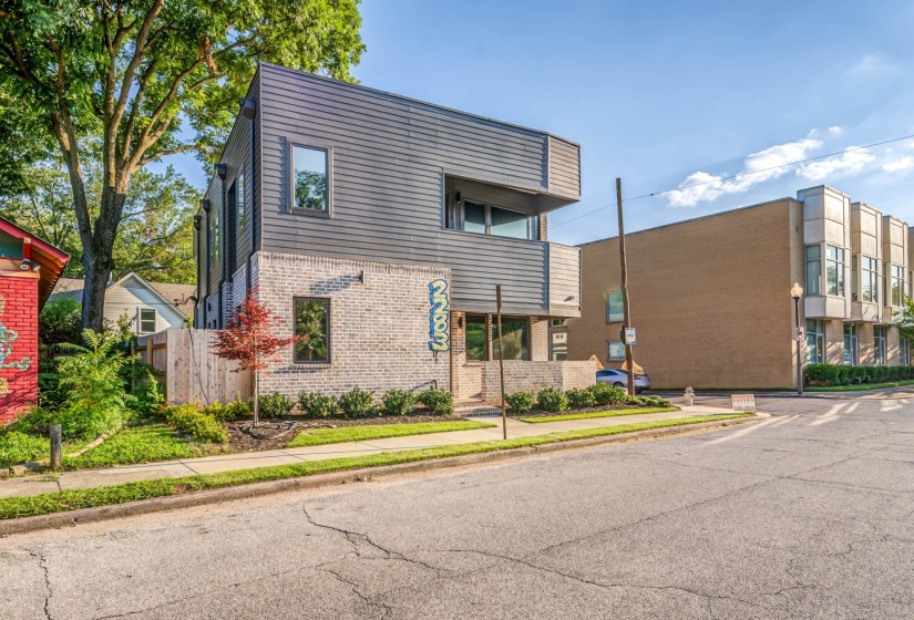 Modern home featuring brick siding and fence