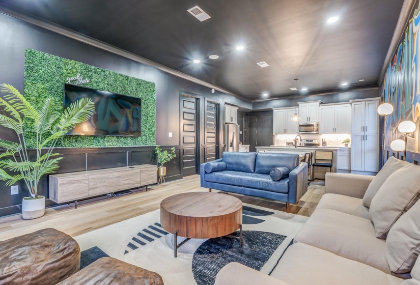 Living area with recessed lighting, light wood-style floors, visible vents, and ornamental molding