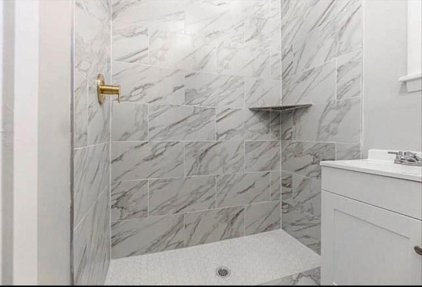 Bathroom with a tile shower and vanity