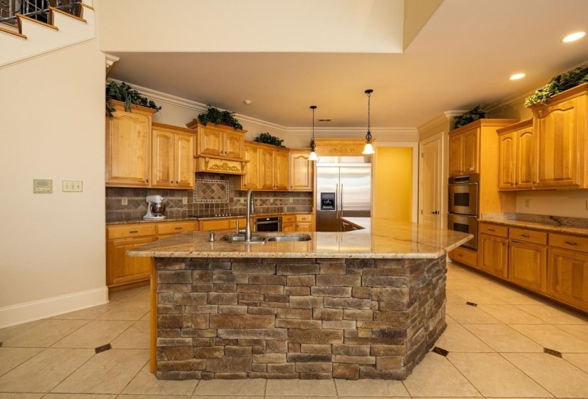 Kitchen featuring light tile patterned floors, crown molding, stainless steel appliances, and a sink