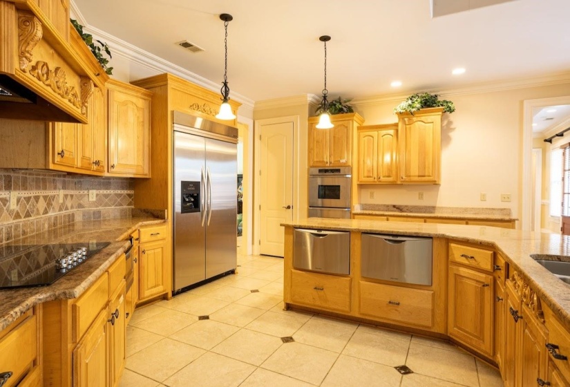 Kitchen with a warming drawer, appliances with stainless steel finishes, tasteful backsplash, and visible vents