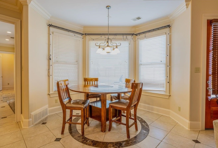 Dining room featuring ornamental molding, visible vents, and light tile patterned floors