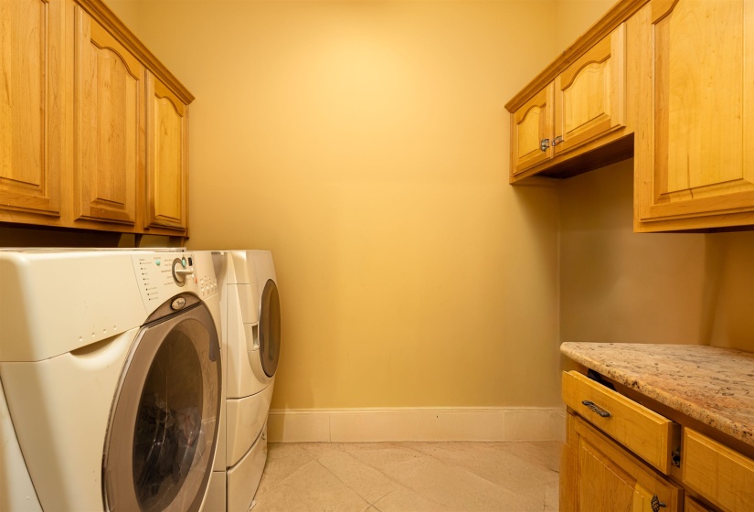 Washroom with washing machine and clothes dryer, cabinet space, baseboards, and light tile patterned floors