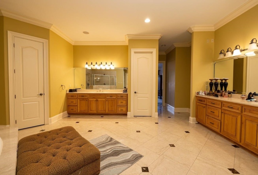Bathroom featuring a shower stall, baseboards, and ornamental molding