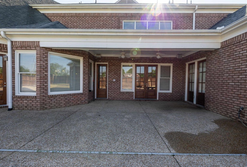 View of exterior entry with brick siding, a ceiling fan, and french doors