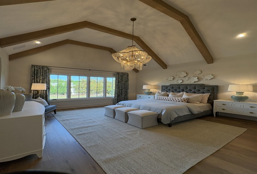 Bedroom with beamed ceiling, wood finished floors, high vaulted ceiling, and a notable chandelier