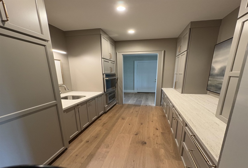 Kitchen featuring a sink, gray cabinetry, light wood-style flooring, recessed lighting, and light stone countertops
