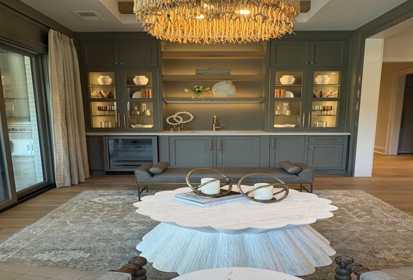 Bar featuring a sink, a chandelier, light wood finished floors, wine cooler, and visible vents