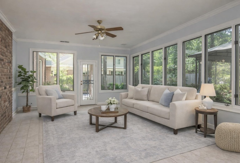 Sunroom / solarium with brick wall, tile patterned flooring, and ornamental molding