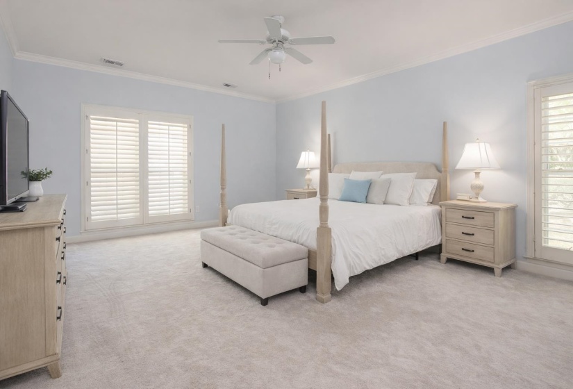 Bedroom with ornamental molding, a ceiling fan, and light carpet