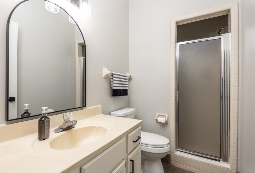 Bathroom featuring vanity, a shower stall, and toilet