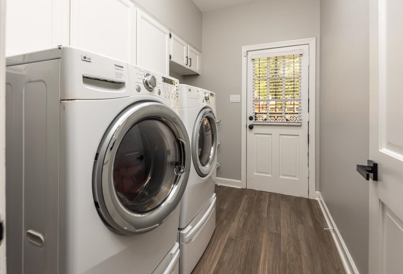 Laundry room featuring cabinet space, baseboards, dark wood-style flooring, and washer and clothes dryer