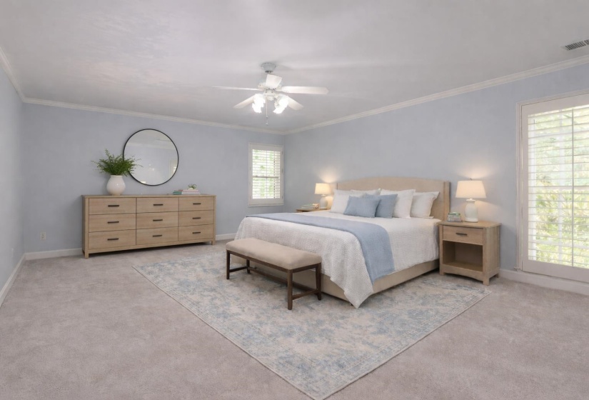 Bedroom with light carpet, ornamental molding, and a ceiling fan