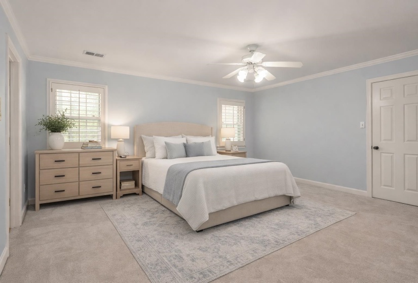 Bedroom with light colored carpet, ornamental molding, and ceiling fan
