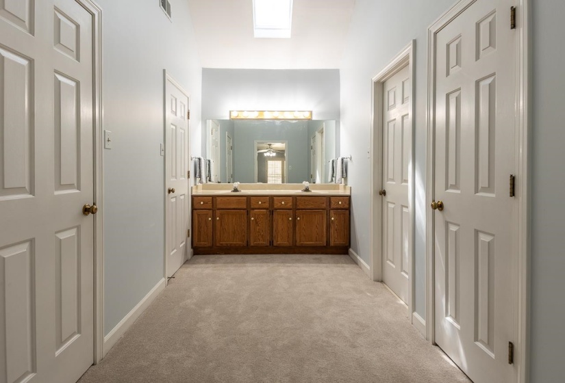 Bathroom with double vanity and light carpet