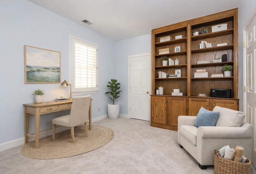 Home office with light colored carpet and baseboards