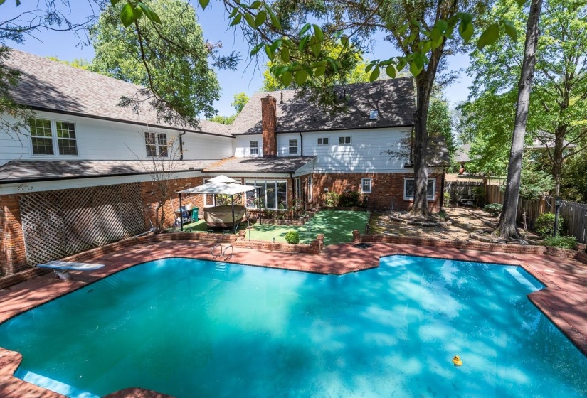 Back of house with brick siding and a patio