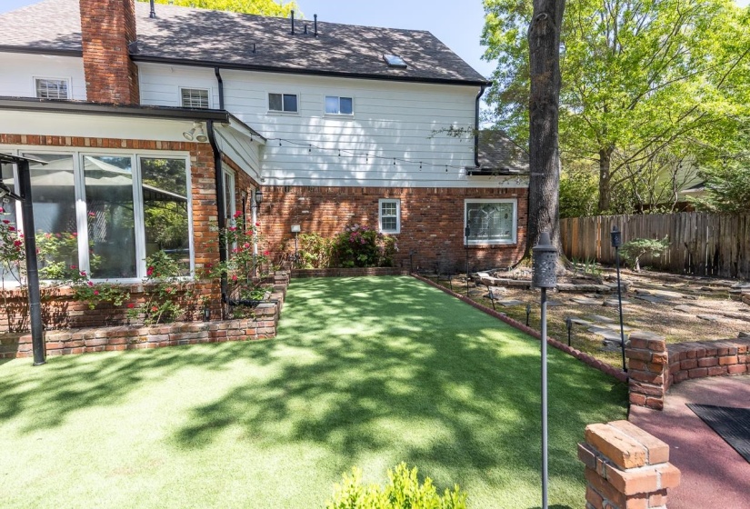 Back of property with brick siding, a chimney, and roof with shingles