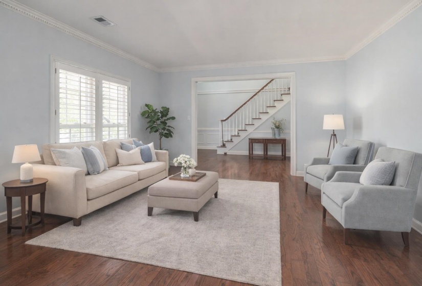Living room featuring dark wood finished floors and crown molding