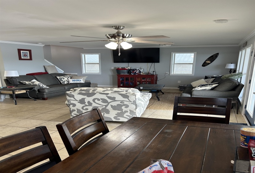 Dining room featuring ceiling fan, a healthy amount of sunlight, ornamental molding, and light tile patterned floors Dining room featuring ceiling fan, a healthy amount of sunlight, ornamental molding, and light tile patterned floors