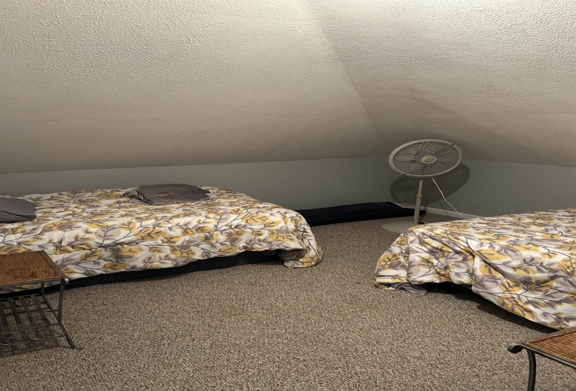 Carpeted bedroom with vaulted ceiling and a textured ceiling Carpeted bedroom with vaulted ceiling and a textured ceiling