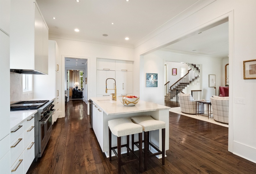 Kitchen featuring range with two ovens, ornamental molding, modern cabinets, light countertops, and white cabinets