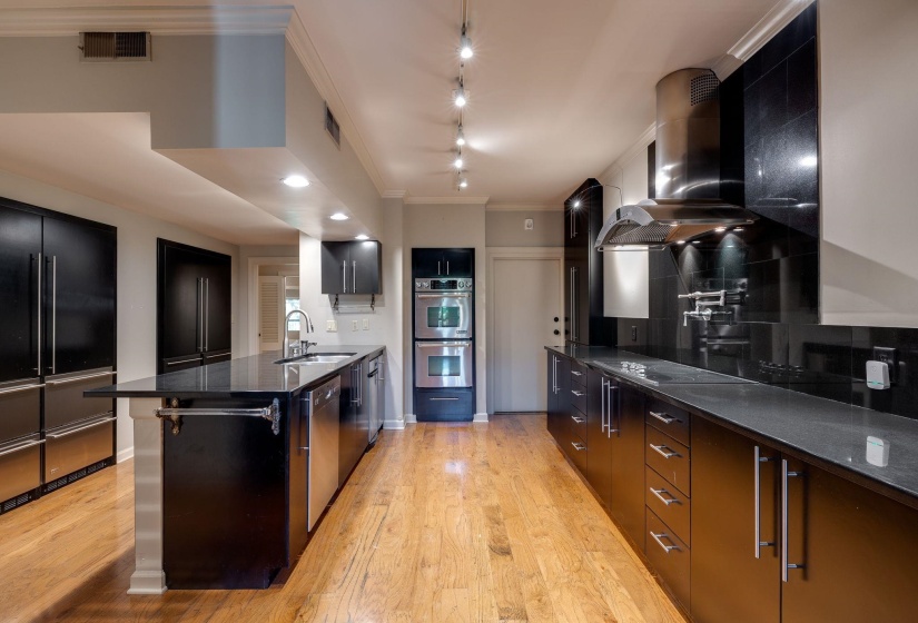 Kitchen featuring stainless steel appliances, a sink, track lighting, modern cabinets, and hardwood flooring