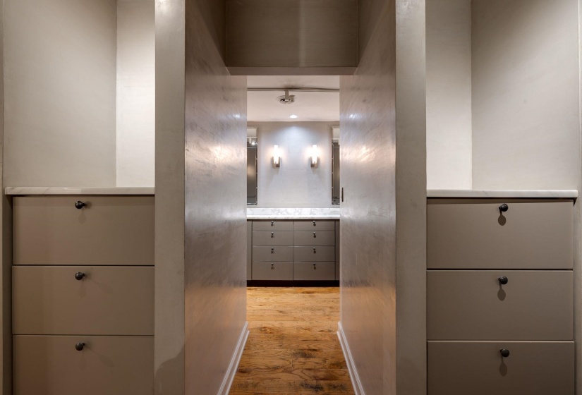 Corridor to primary bedroom featuring hardwood floors