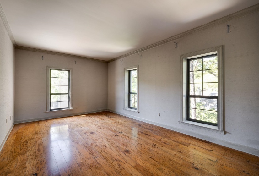 Unfurnished room featuring wood hardwood floors, baseboards, and crown molding
