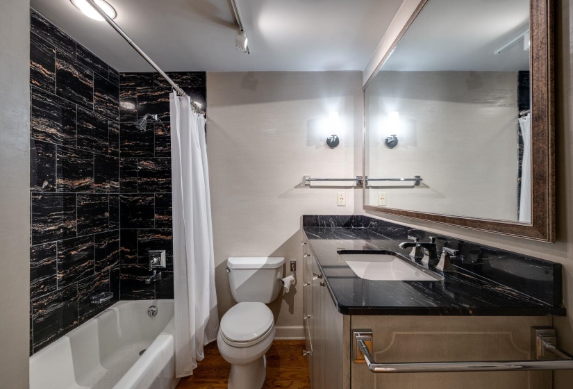 Full bath featuring toilet, vanity, shower / bath combination with curtain, and hardwood floors