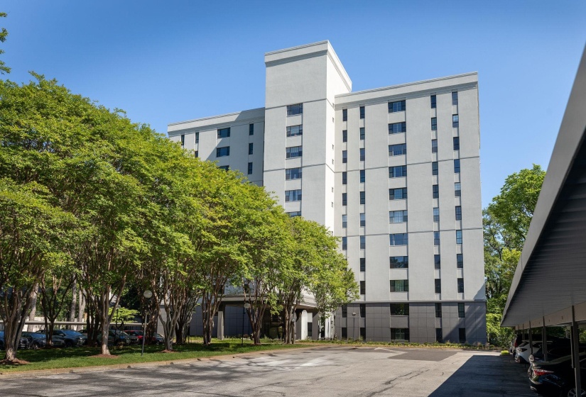 View of building exterior featuring uncovered parking
