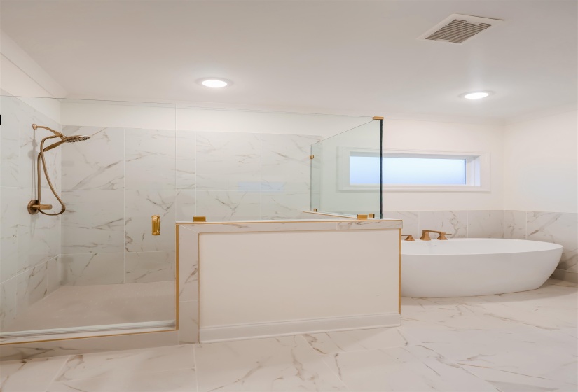 Bathroom with wainscoting, a marble finish shower, tile walls, a freestanding tub, and marble tiled flooring