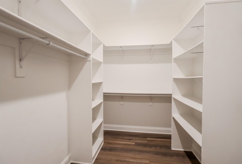 Spacious closet with dark wood-style floors