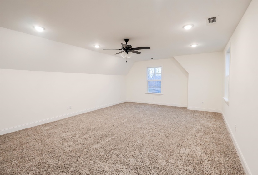 Additional living space with light carpet, recessed lighting, lofted ceiling, and ceiling fan