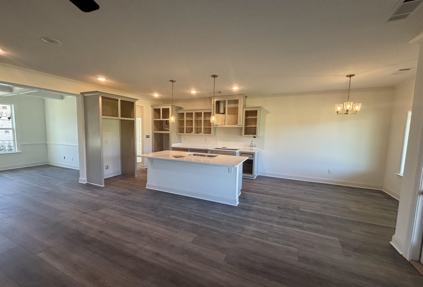 Kitchen with open floor plan, decorative light fixtures, recessed lighting, a center island, and dark wood-type flooring