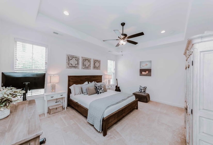 Bedroom featuring a raised ceiling, visible vents, recessed lighting, and light colored carpet