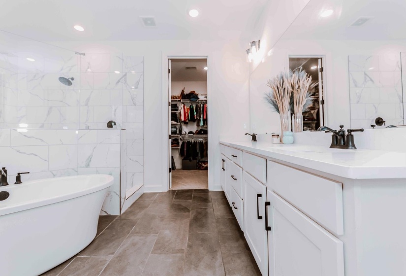 Full bathroom with vanity, recessed lighting, a spacious closet, a soaking tub, and a tile shower