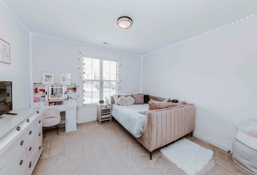 Bedroom featuring baseboards, visible vents, and light carpet
